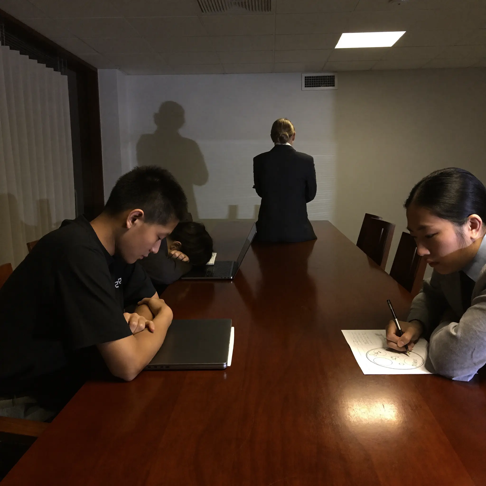 A tense conference room with a standing manager and disengaged team members.