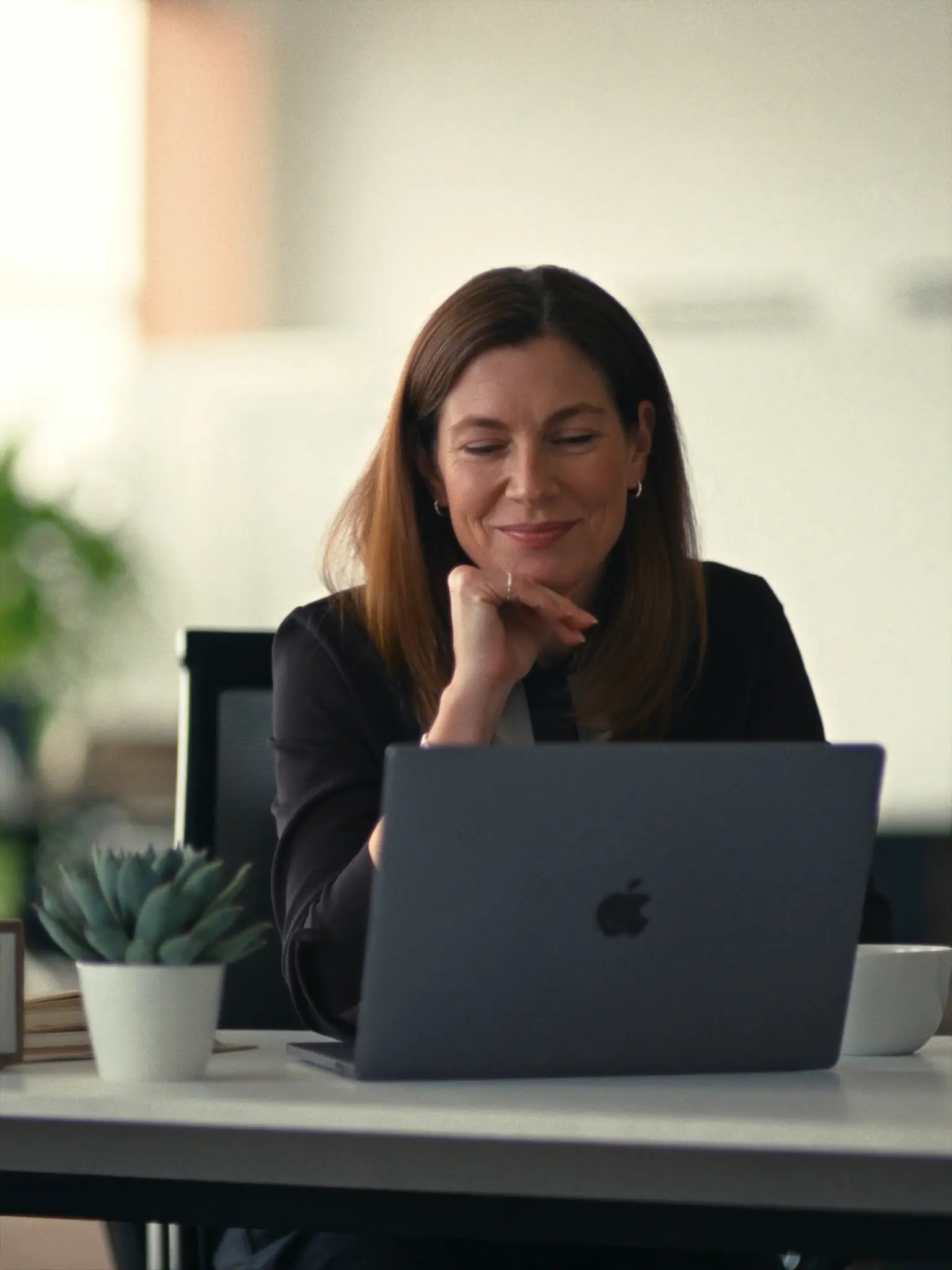 HR director calmly reviewing data on her laptop in the morning
